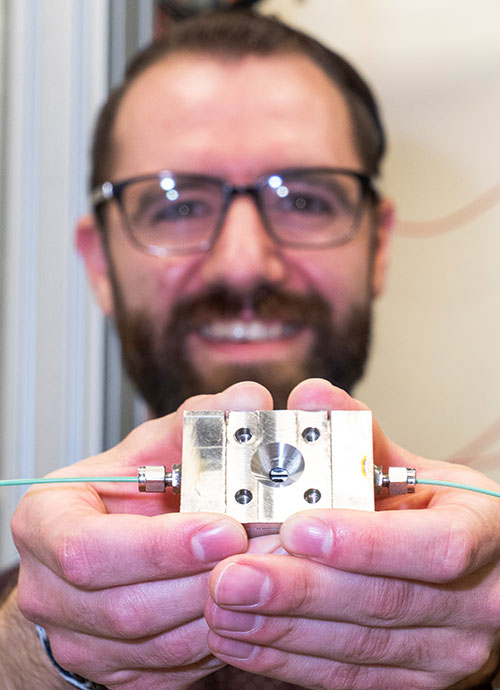 Steven Farrell holds a reaction chamber
