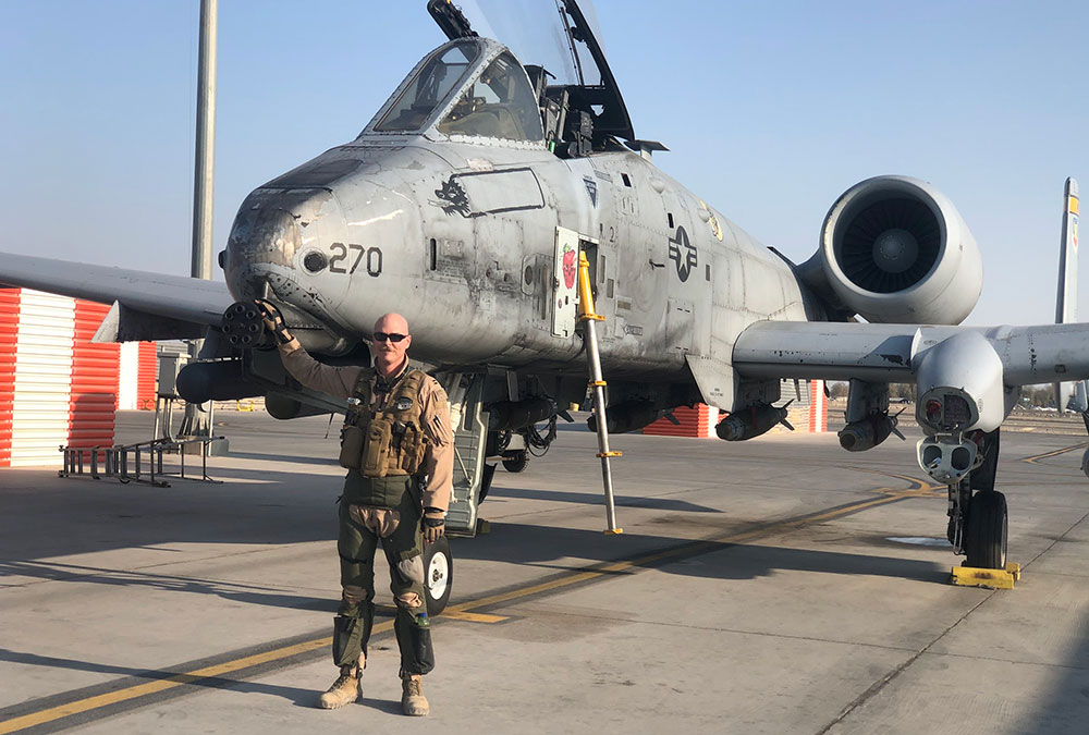 Jordan Ziegler stands in front of an A-10 Thunderbolt II fighter jet during his U.S. Air Force deplo