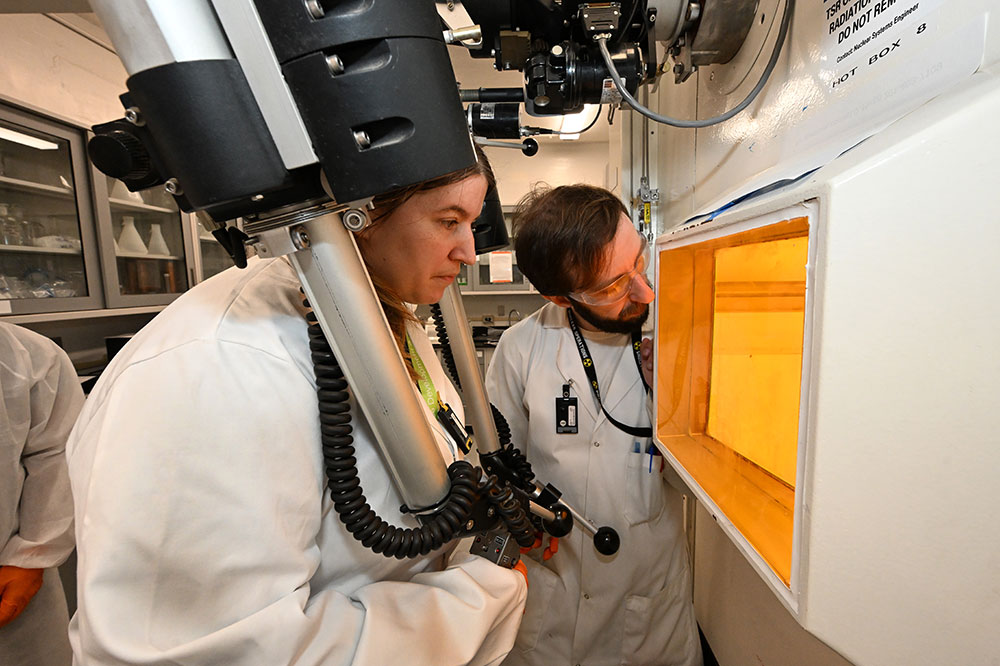 Arin Morton (left) simulates operating equipment in a hot cell facility