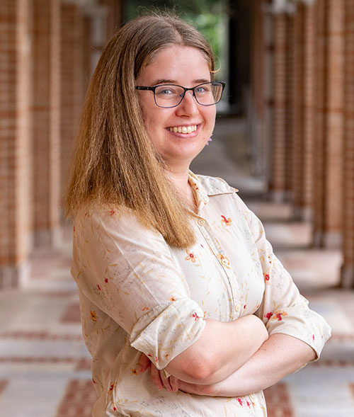 Nicole Lewis, then a postdoctoral fellow at Brookhaven Lab, stands outdoors with arms crossed near l