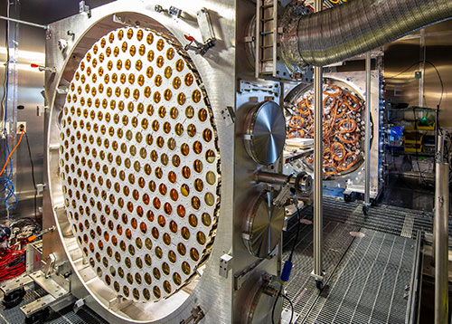 Large detector component filled with dozens of gold-colored photosensors, with cables and additional