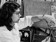 Black-and-white photo of researcher works with a piece of equipment known as the "fast neutron