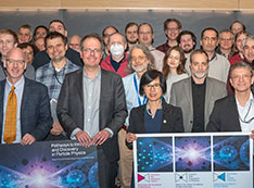 Group poses on stage with P5 presentation posters