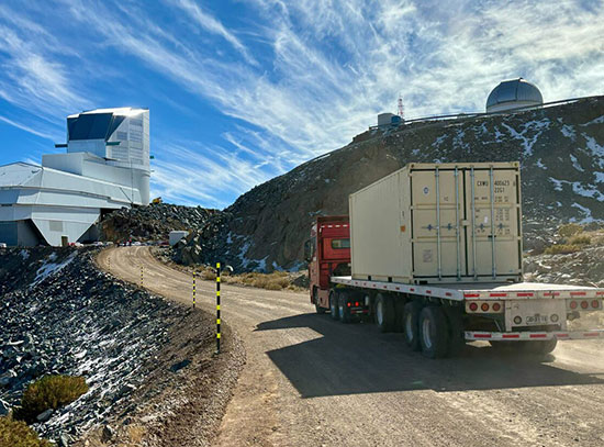 A truck drives up a gravel road towards the Rubin Observatory