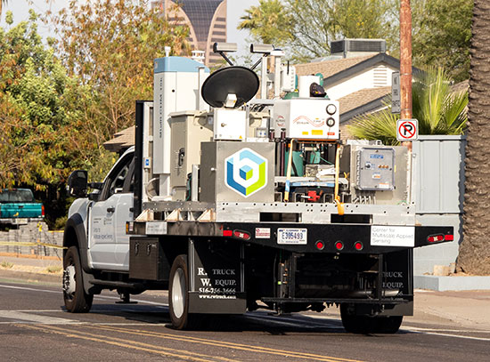 Mobile observatory truck on a a palm tree-lined street