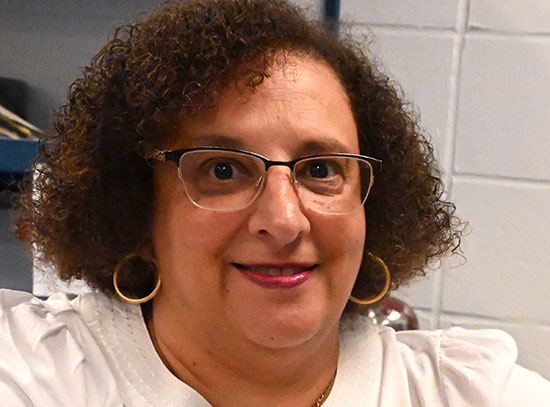 A woman wears a white, short-sleeved shirt and a blue grounding band around her wrist designed to ne