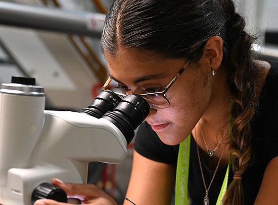 A student peers into a microscope