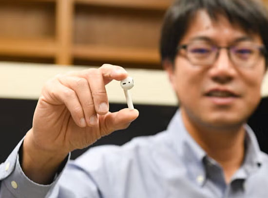 Yijin Liu holding an earbud