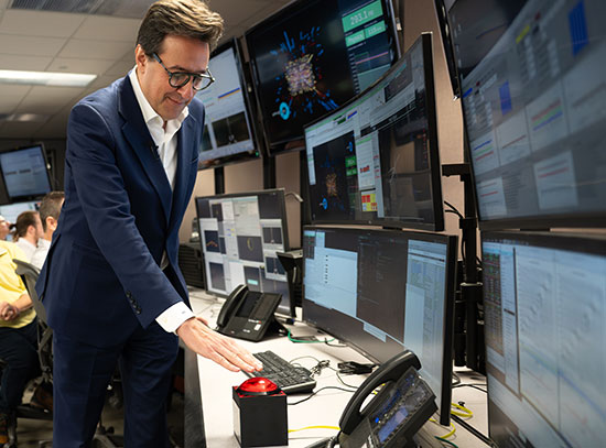 Dar&iacute;o Gil presses a red button in the Main Control Room for RHIC