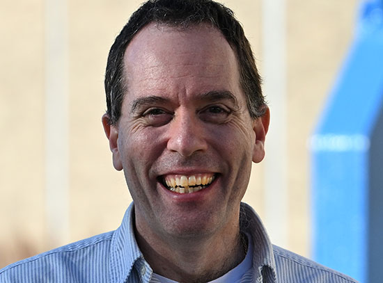 Seth Nemesure stands outside the Collider-Accelerator Division building at Brookhaven Lab