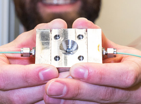 Steven Farrell holds a reaction chamber