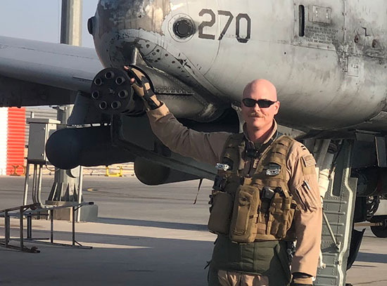 Jordan Ziegler stands in front of an A-10 Thunderbolt II fighter jet during his U.S. Air Force deplo