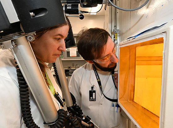 Arin Morton (left) simulates operating equipment in a hot cell facility