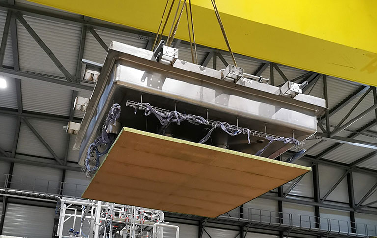 A crane lowers a charge readout plane attached to the top of the cryogenic vessel onto the vessel