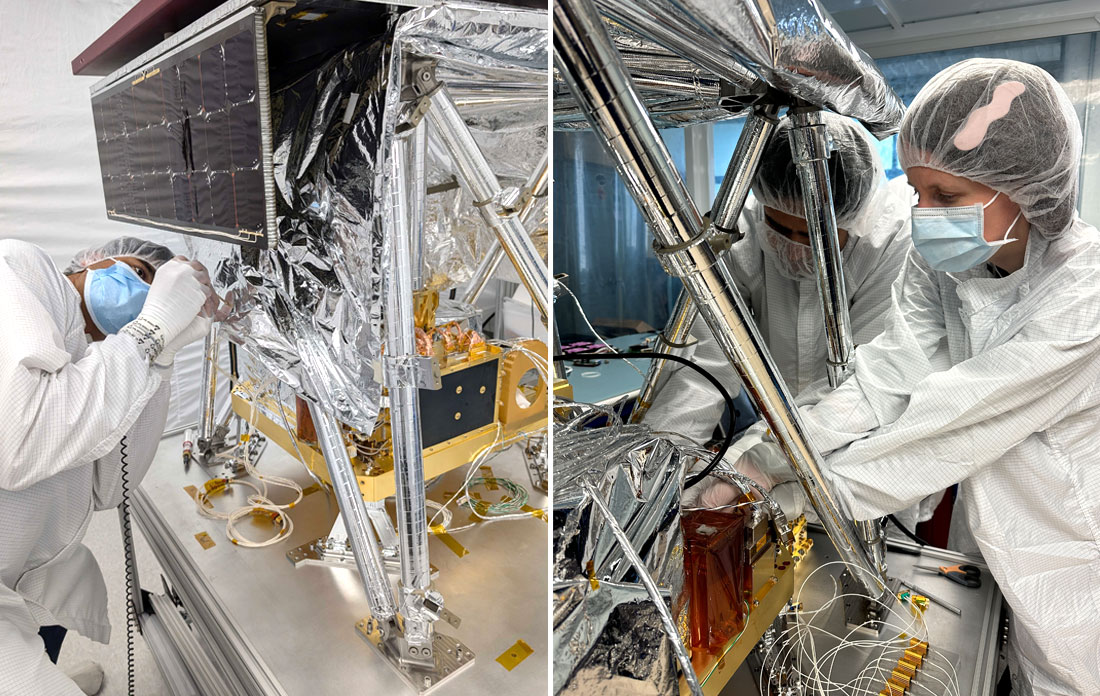 Engineers wearing clean room gear assemble machinery