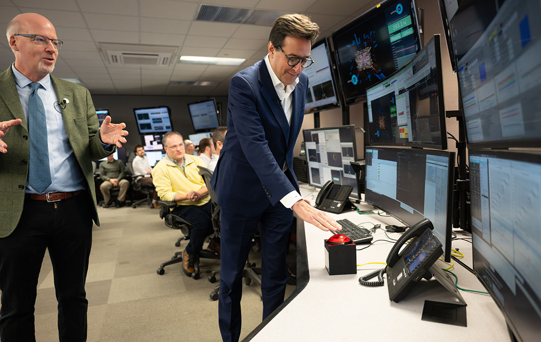 Dar&iacute;o Gil presses a red button in the Main Control Room for RHIC