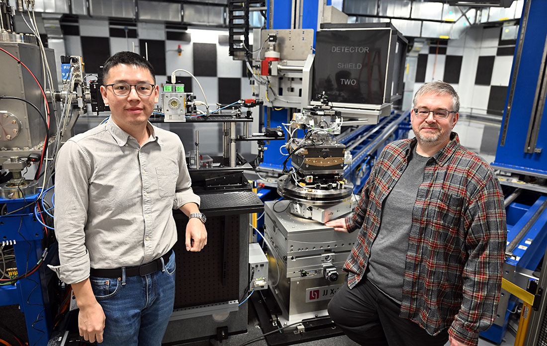 Yuan Gao and Garth Williams stand beside an area detector at the Coherent Diffractive Imaging beamli