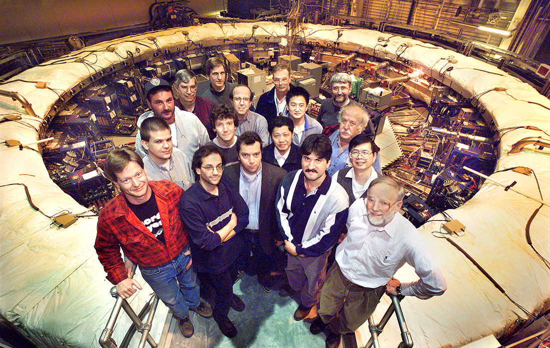 Members of the Brookhaven muon g-2 collaboration pose around the storage ring magnet in 2001.