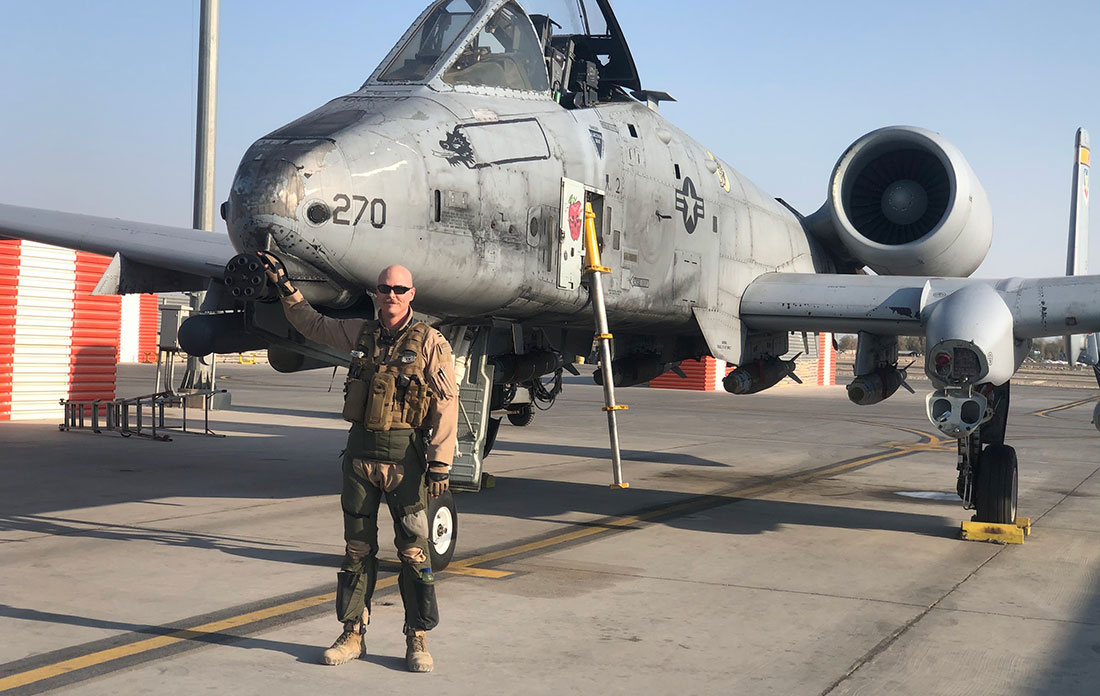 Jordan Ziegler stands in front of an A-10 Thunderbolt II fighter jet during his U.S. Air Force deplo