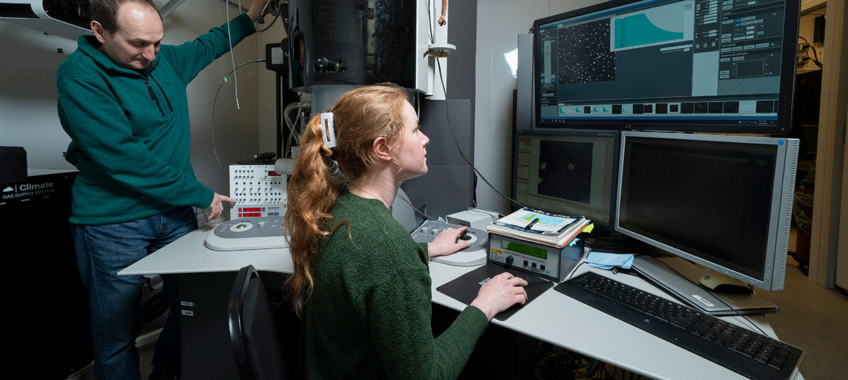 photo of a man and woman working at an electron microscope